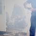An Ann Arbor firefighter works on a piece of his gear as fog, or simulated smoke is blown into a training exercise at Parkhurst Apartments on Wednesday. Melanie Maxwell I AnnArbor.com 